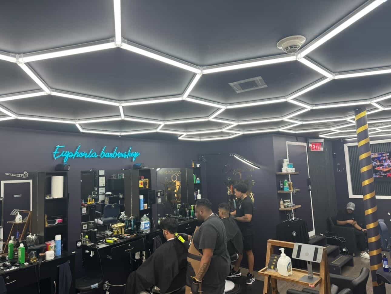 Inside Euphoria Barbershop — the hexagon-light ceiling and chairs